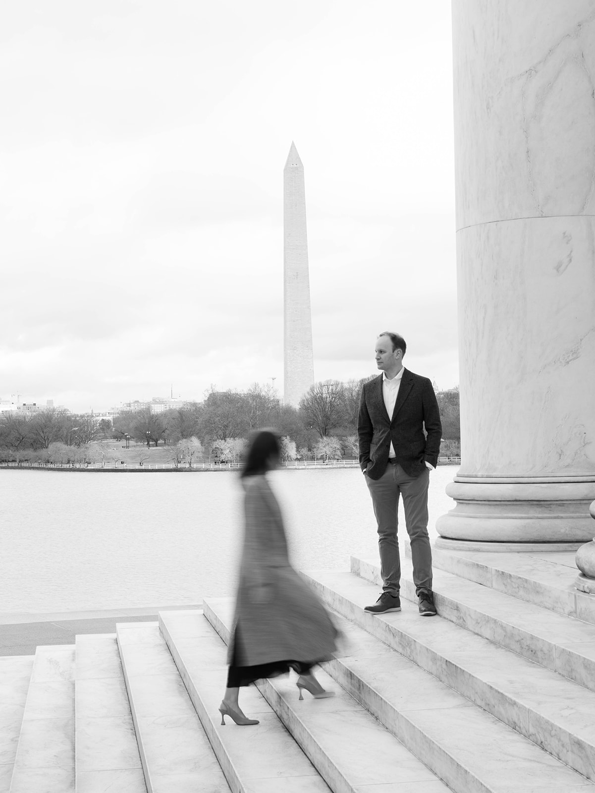 Couple walking in front of the reflection pond at the Jefferson Memorial, one of the best engagement photo locations in DC. In black and white.